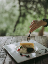 Midsection of person holding ice cream on table