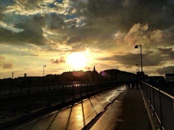 City street against cloudy sky during sunset