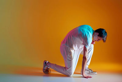 Rear view of woman standing against yellow background