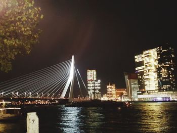 Illuminated bridge over river at night