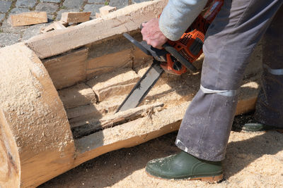 Chainsaw,close-up of woodcutter sawing chain saw in motion, sawdust fly to sides