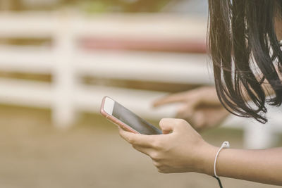 Midsection of woman using mobile phone