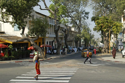 People walking on road along buildings