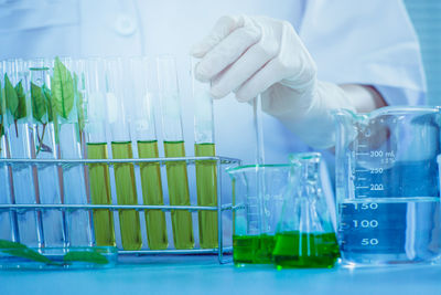 Midsection of scientist performing experiment on chemicals in laboratory