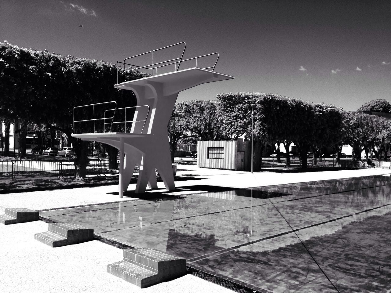 tree, built structure, architecture, park - man made space, building exterior, sunlight, bench, shadow, sky, park, outdoors, day, sculpture, clear sky, footpath, no people, absence, architectural column, incidental people, growth