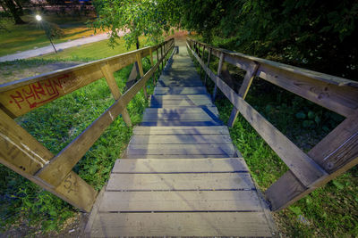 Empty footbridge along trees