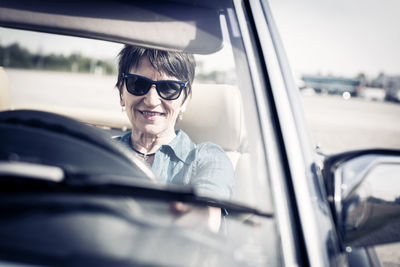 Portrait of woman wearing sunglasses in car