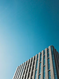 Low angle view of modern building against clear blue sky