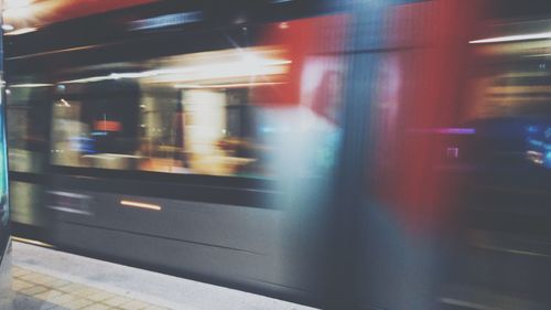 Train moving on railroad station platform at night