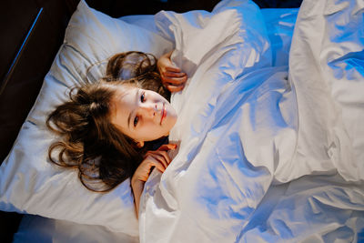 High angle view of woman sleeping on bed