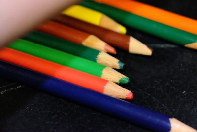Close-up of colored pencils on black table