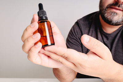 Midsection of man holding bottle