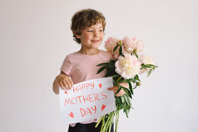 Happy mothers day. cheerful happy child with peonys bouquet.