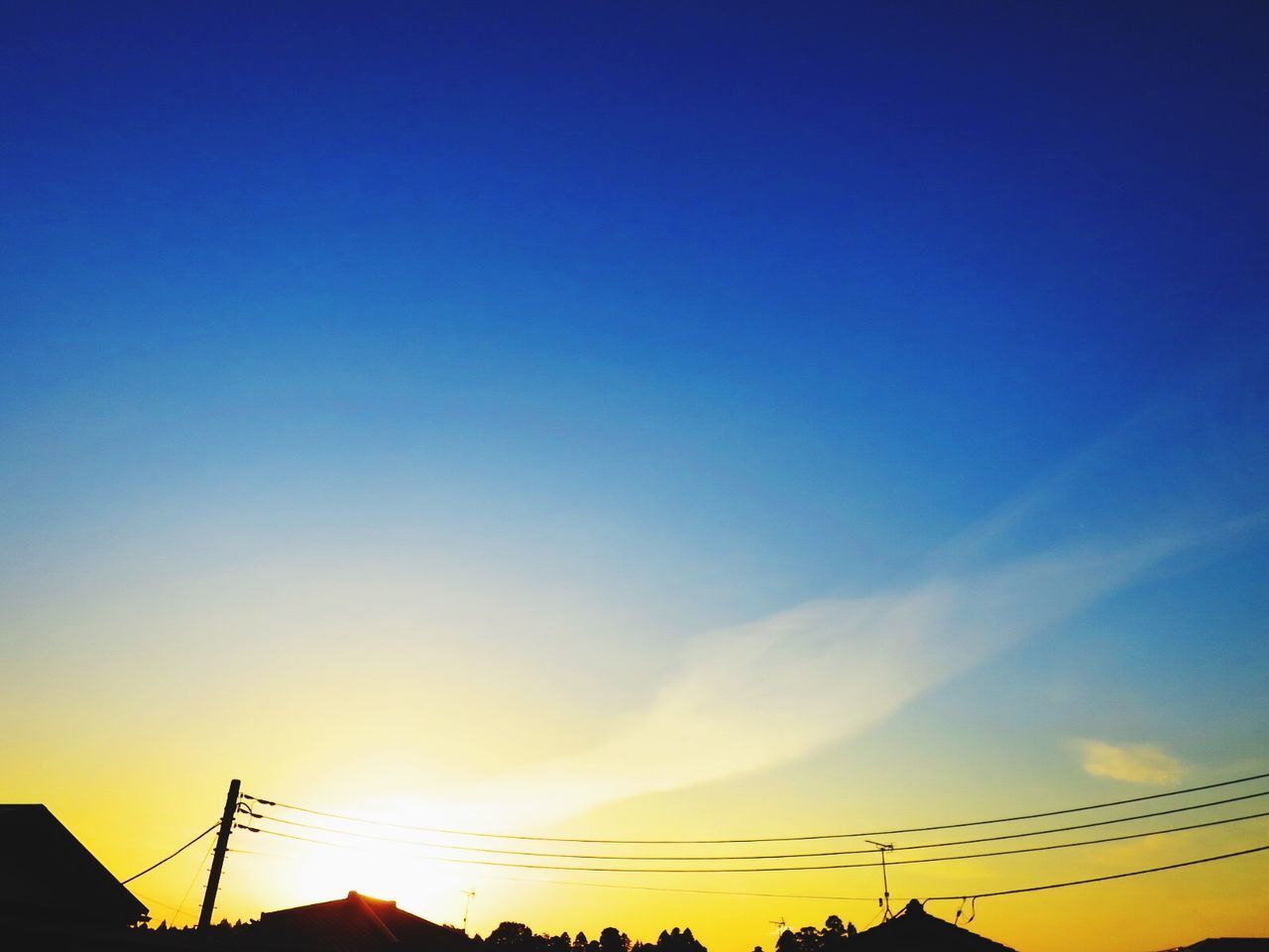 LOW ANGLE VIEW OF SILHOUETTE ELECTRICITY PYLON AGAINST BLUE SKY