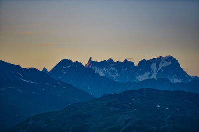 Scenic view of snowcapped mountains against sky during sunset