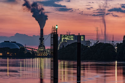 Smoke emitting from factory against sky during sunset