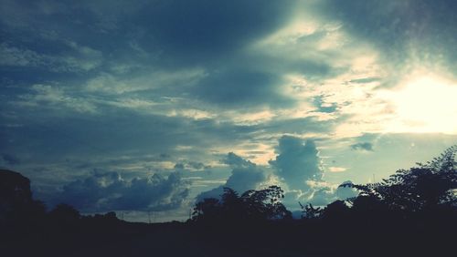 Low angle view of silhouette trees against sky