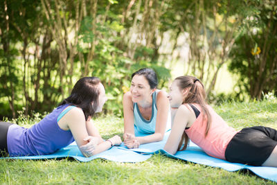 Mother talking with daughters while lying at park