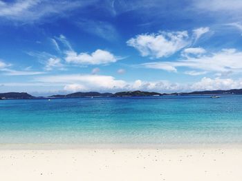 View of calm beach against blue sky