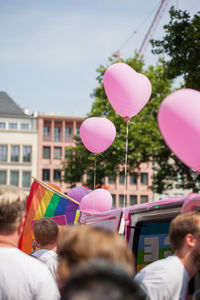 People by balloons against sky