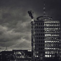 Low angle view of illuminated buildings against cloudy sky