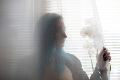 Portrait of woman holding white window