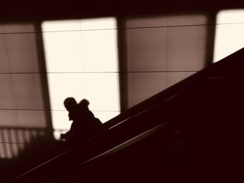 Low angle view of silhouette man standing on tiled floor