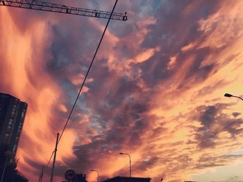 Low angle view of power lines against cloudy sky