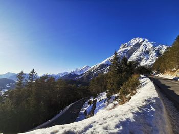 Scenic view of snowcapped mountains against clear blue sky