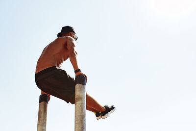 Low angle view of man climbing on white background