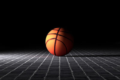 Close-up of basketball ball against black background