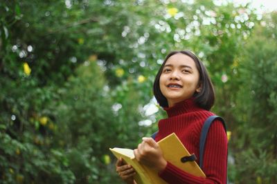 Smiling teenage girl standing at park