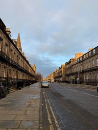 Street amidst buildings in city against sky