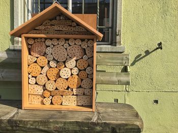 Wooden insect hotel on table against window