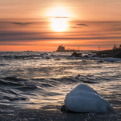 Scenic view of sea against dramatic sky during sunset