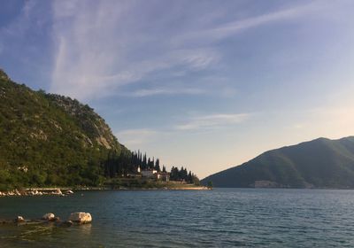 Scenic view of lake by mountains against sky