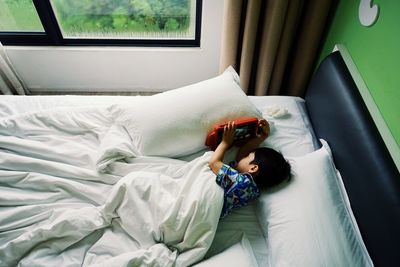 High angle view of boy resting on bed at home