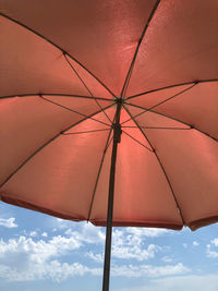 Low angle view of parasol against sky