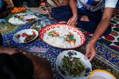 High angle view of people holding food on table