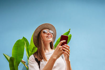 Excited young female on vacation uses smartphone