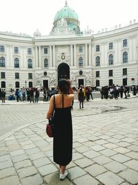 Rear view of people walking in front of building