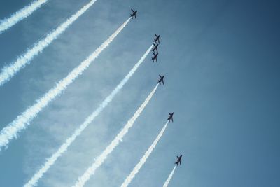 Low angle view of red arrows flying in sky