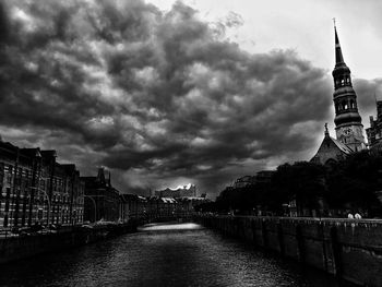 Buildings in city against cloudy sky