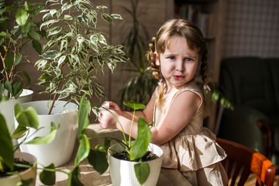 Portrait of cute girl sitting on plant