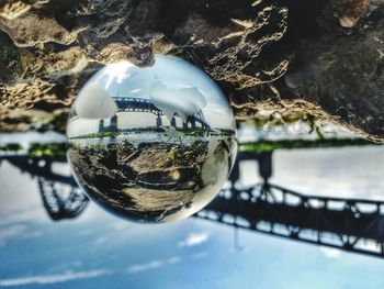 Close-up of crystal ball against trees