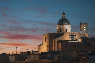 Low angle view of buildings against sky during sunset