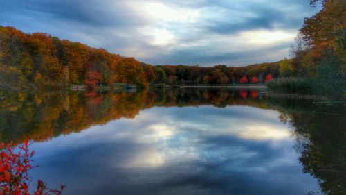 Scenic view of lake by trees against sky