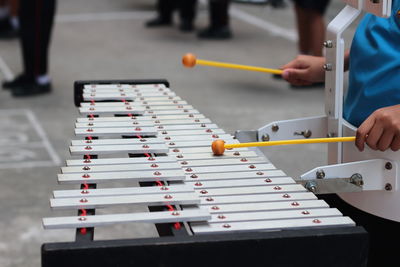 Cropped image of person playing xylophone in city