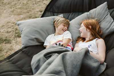 Brother and sister lying in hammock