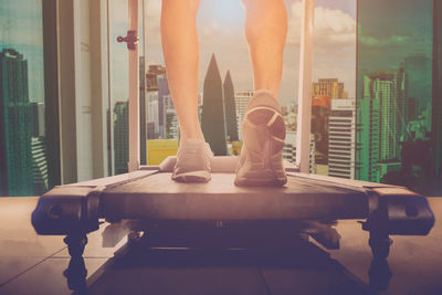 Low section of woman standing on tiled floor at home